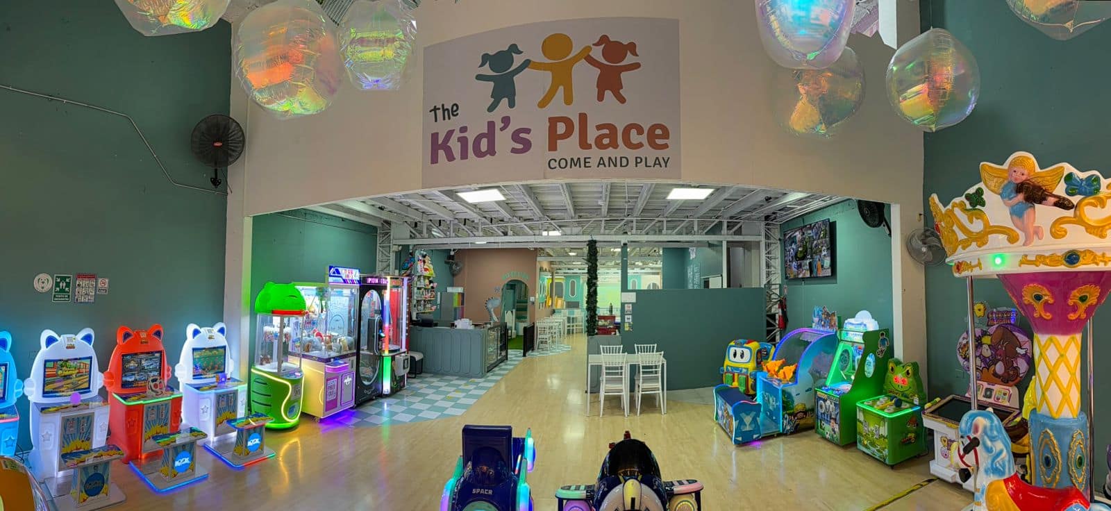 Piscina de pelotas con tobogán y pantalla de juego en el playground de The Kid's Place