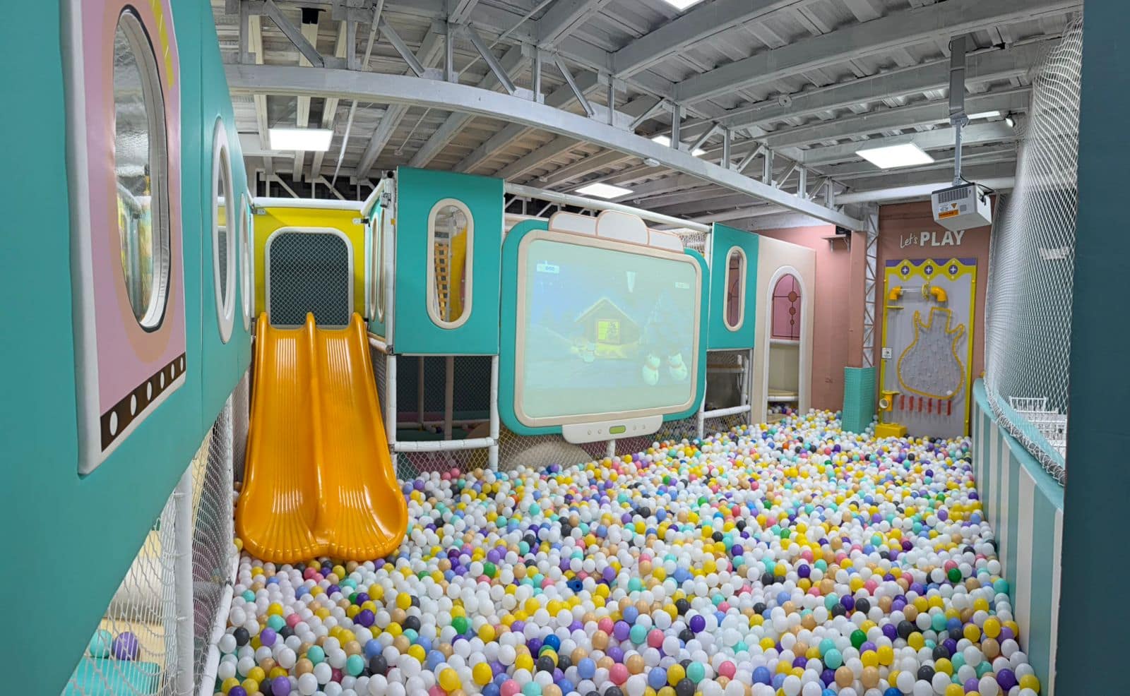 Piscina de pelotas con tobogán y pantalla de proyección