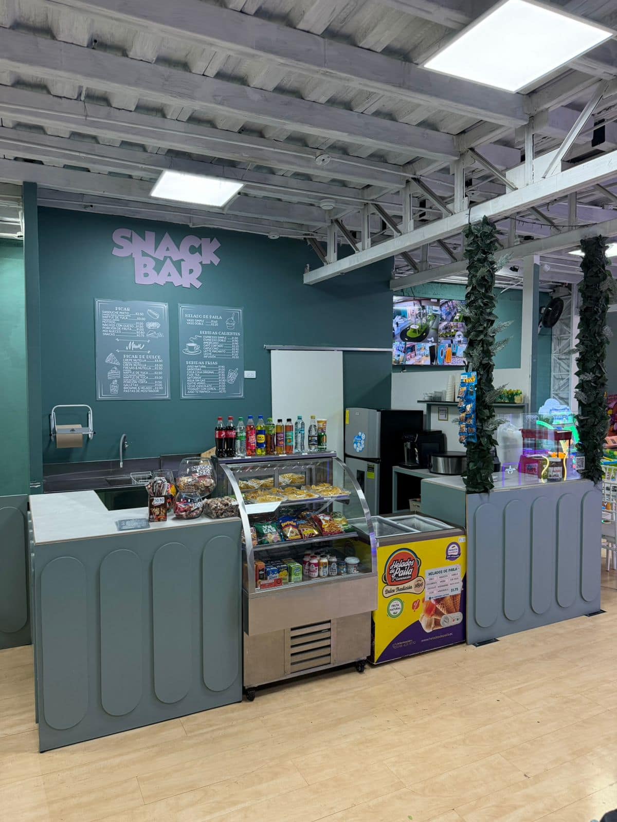 Barra del Snack Bar con vitrina de snacks, bebidas y helado de paila